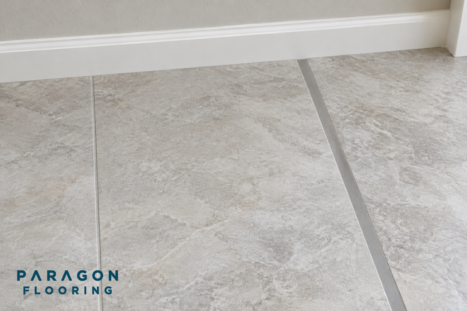 Tiles shown with narrow, medium and wide grout joints next to a wall and baseboard.