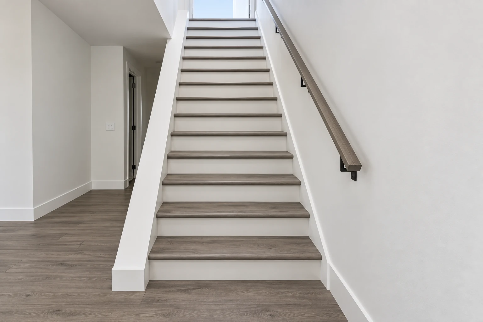 Centered staircase with wood treads, white risers and matching wood flooring, completed with AI from a Paragon project photo