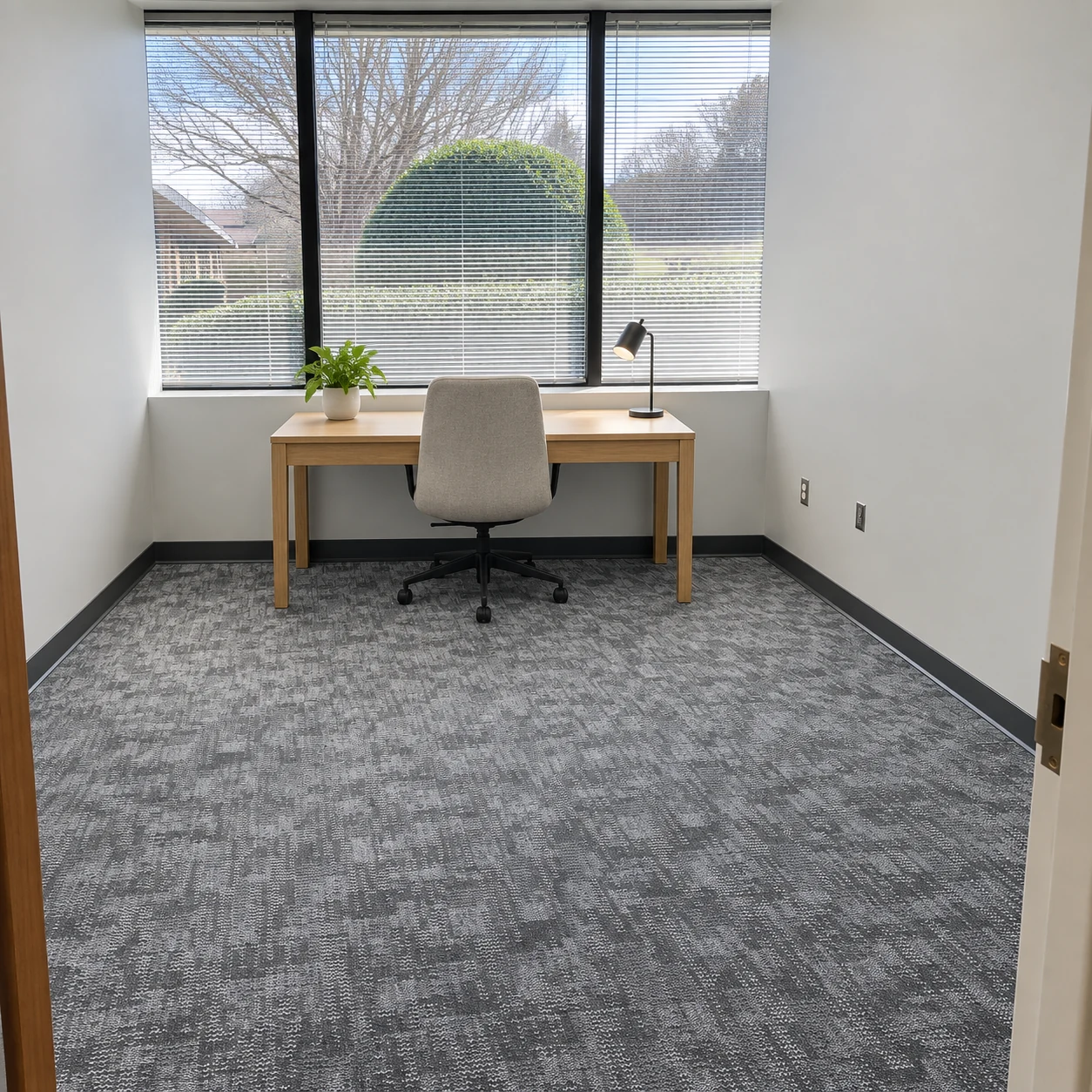 Gray carpet, an oak desk and a window in an AI-completed office based on a Paragon project photograph
